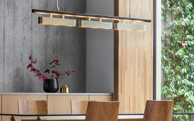 Brass and opal glass pendant lighting hanging above a dining table