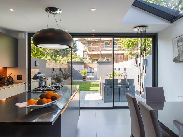 Kitchen island with dining room table and leather chairs overlooking courtyard