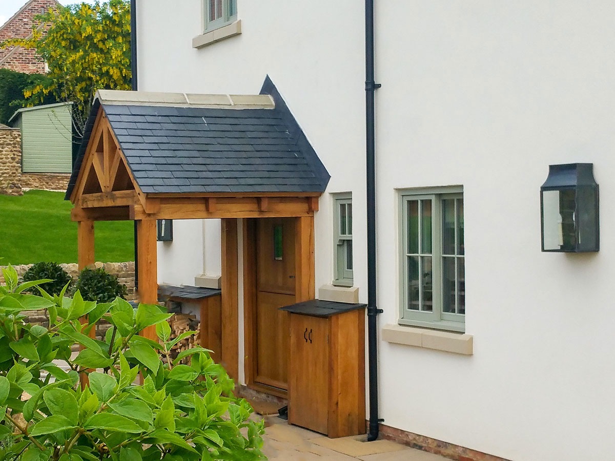 Small oak front porch with wood storage and welly cupboard