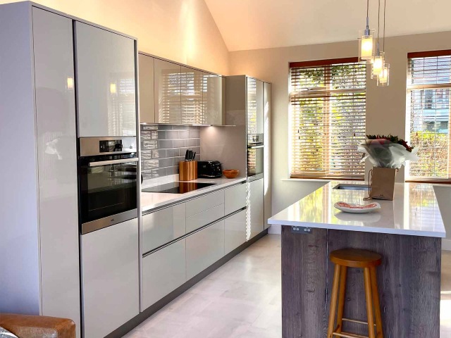 A handleless gloss cashmere kitchen with a tiled floor