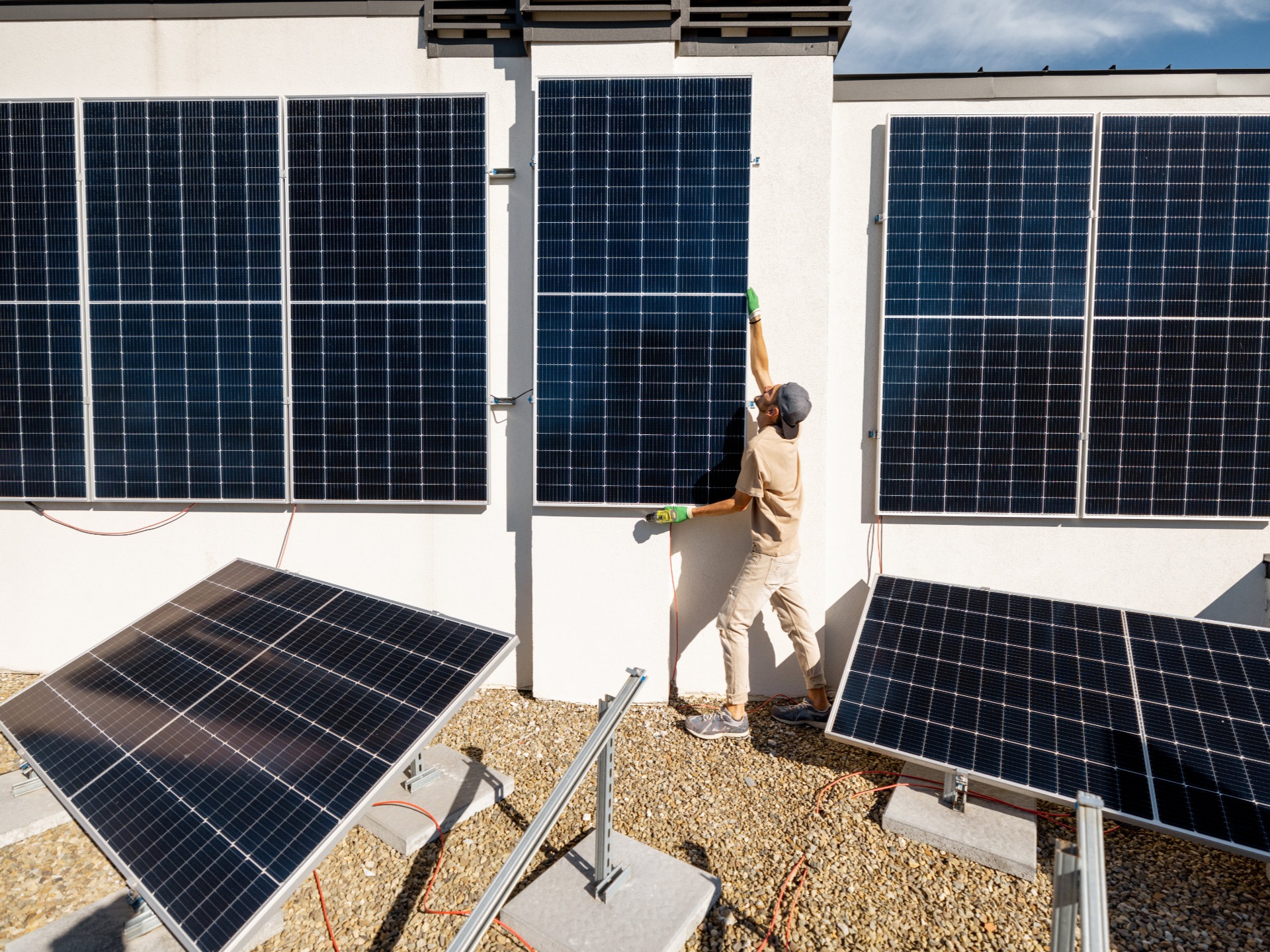 Man installing solar panels on a wall