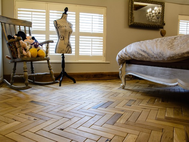 bedroom with bed chair with toys mannequin and wooden flooring