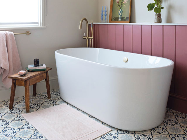 vintage bathroom white freestanding bath gold mixer tap pink wooden panelling white and blue ornate tiles