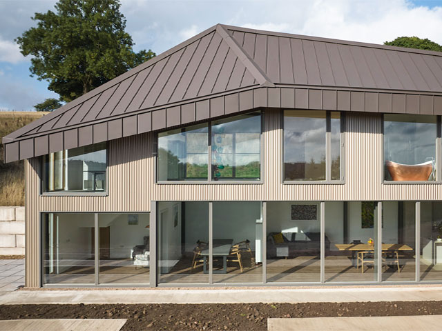 a 21st century longhouse with floor to ceiling windows and angled roof