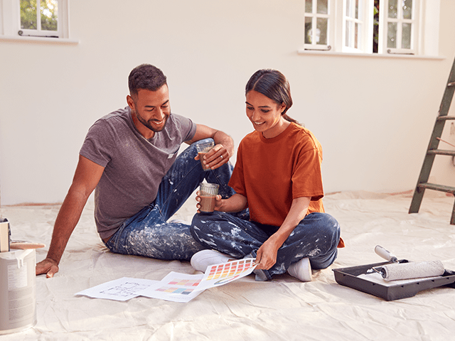 young couple renovating their home consult a colour chart