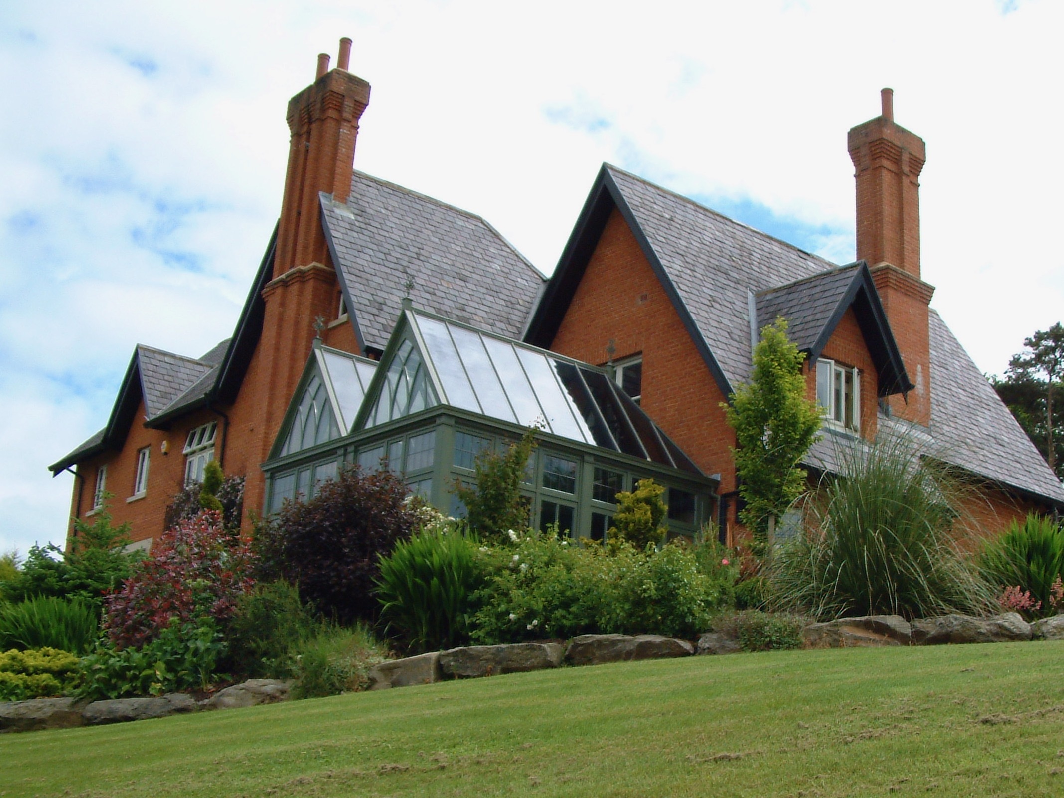 Conservatory with double pitched roof by Hamptons Conservatories