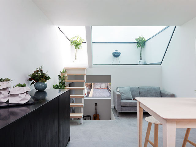 Small interior of Passivhaus with stairs leading to roof terrace.