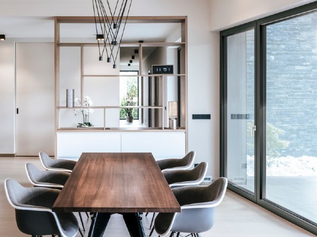 Sliding triple-glazed windows and doors in a modern home with white walls and natural wood decor