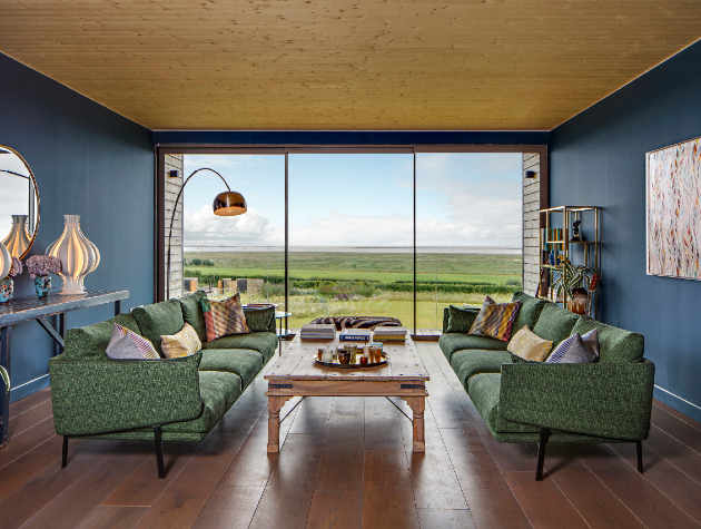 living room with green sofas table patio doors and arc lamp