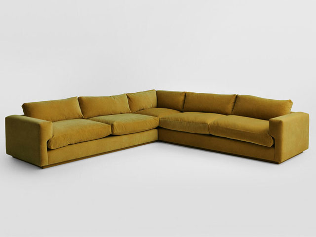 ochre corner sofa in a 70s retro style on a white background