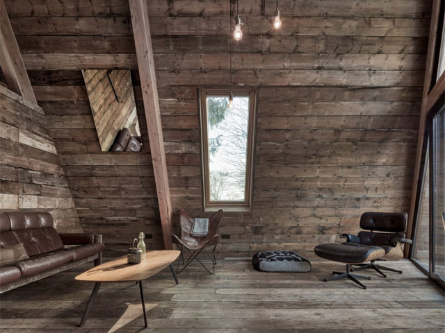 Timber outhouse with leather sofa and coffee table with exposed bulbs