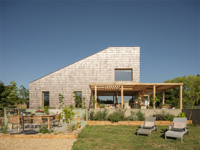 eco home near Bury St Edmunds with silver cladding and wrap around terrace with pergola