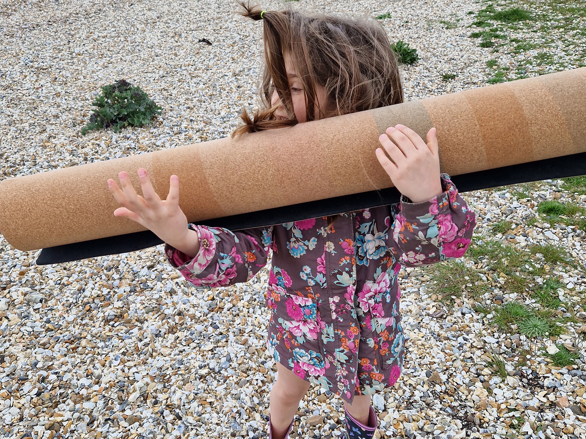 Young girl holding rolled up cord play mat