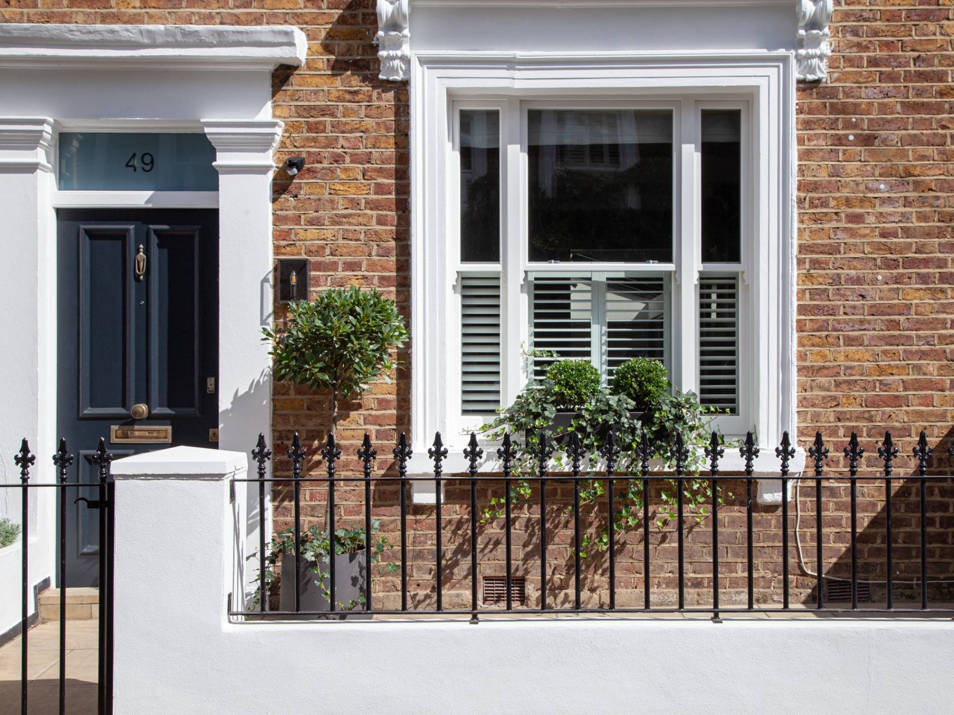 Window box with Ilex domes and ivy in period home front garden