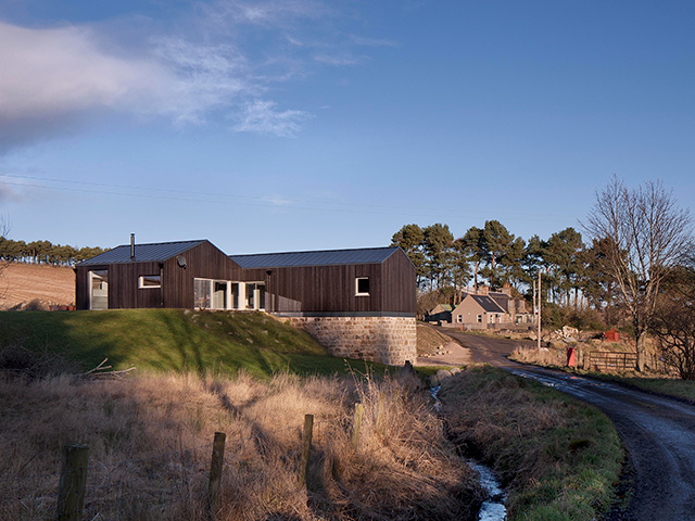 A single-storey house perches on top of an old stone building.