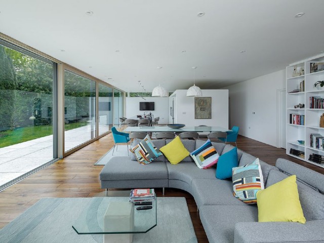 Open-plan kitchen-diner with panoramic sliding triple-glazed windows leading onto the terrace