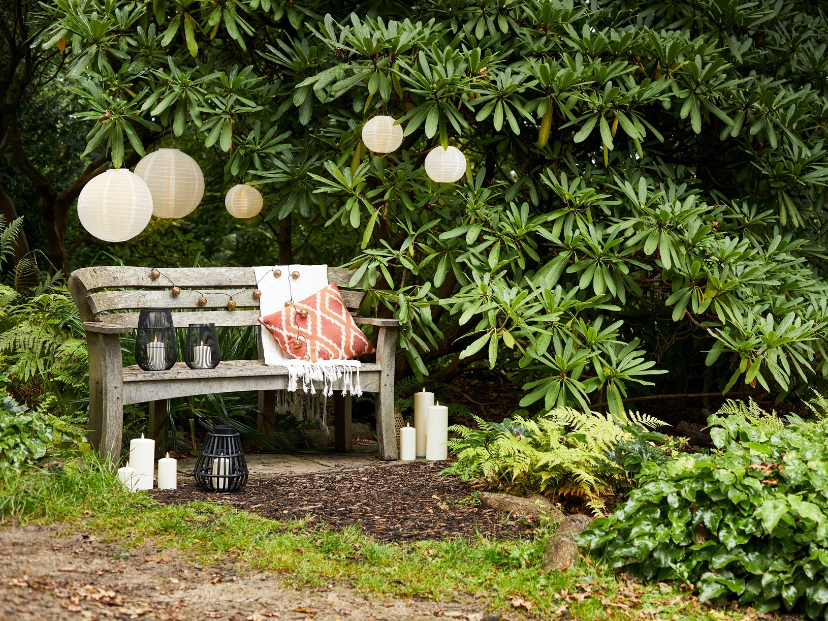 Garden bench with large hedge and lanterns